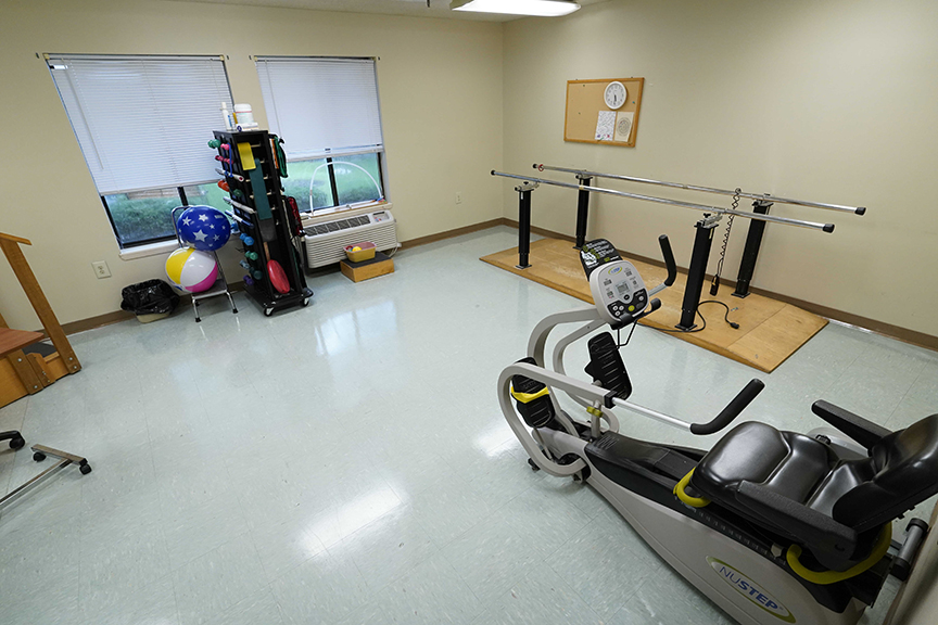 Parallel bar and recumbent bike in physical therapy room- Arbors West