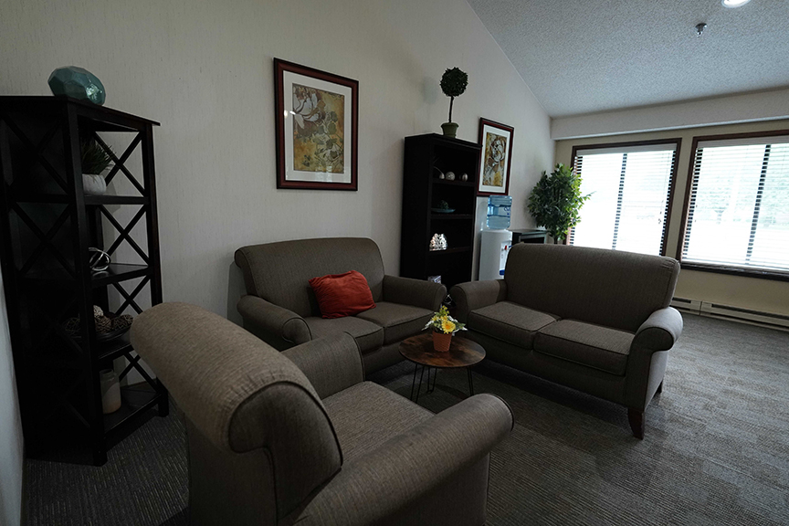 Sofa with center table and flower vase in resident lounge- Arbors West